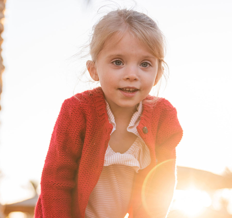 Lächelndes Mädchen in roter Strickjacke
